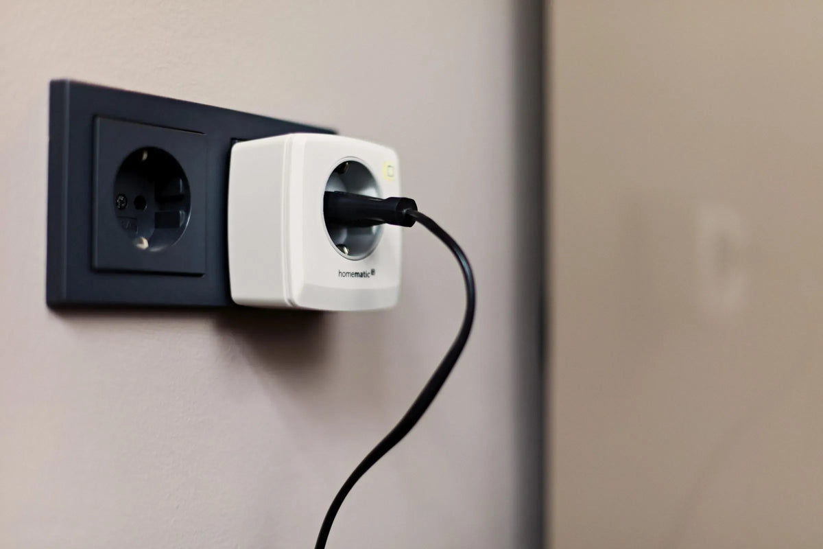 Homematic IP Schaltsteckdose mit angeschlossenem Stecker an einer Wandsteckdose